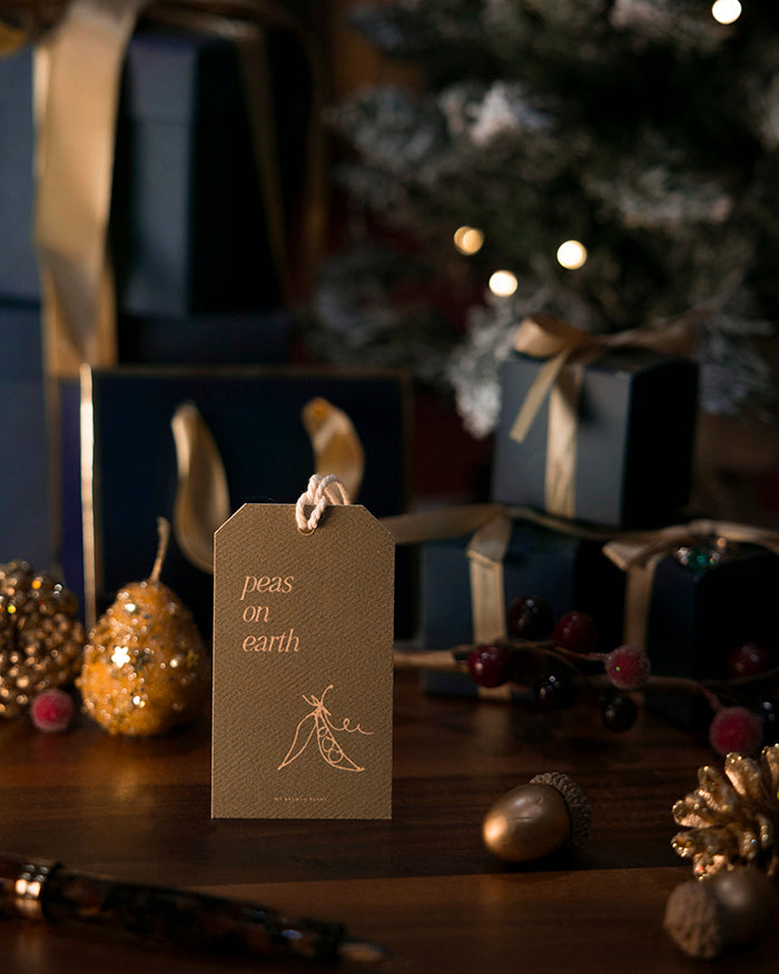 My Brunch Plans' Gift tag with "peas on earth" text in a festive setting with Christmas decorations.