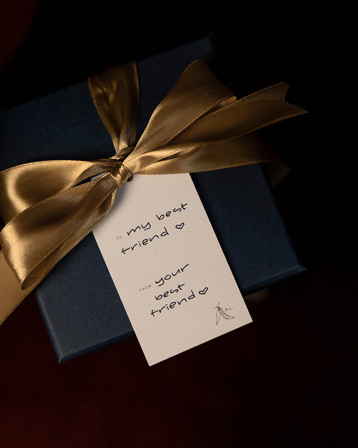 Navy blue gift box with gold ribbon and a personalized My Brunch Plans' gift tag on a dark background. To: "My best friend 'heart'" From: "Your best friend 'heart'"