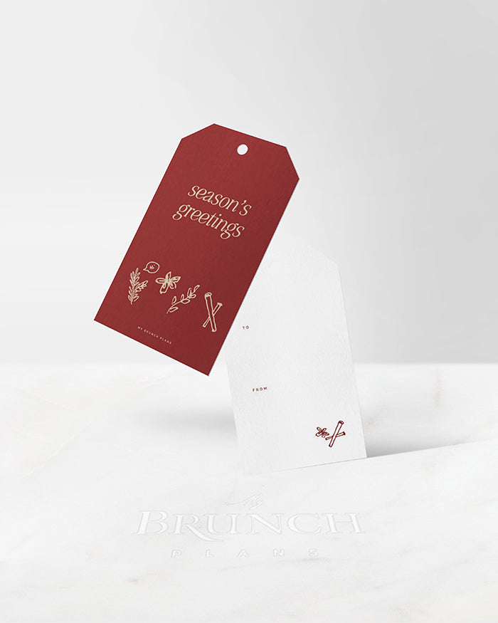 My Brunch Plans’ gift tag on a white background. Front Design features 'season's greetings' with a hand drawn line art of different holiday spices. Back design features a writing area with “to” and “from” and a hand drawn line art of cinnamon and anise.