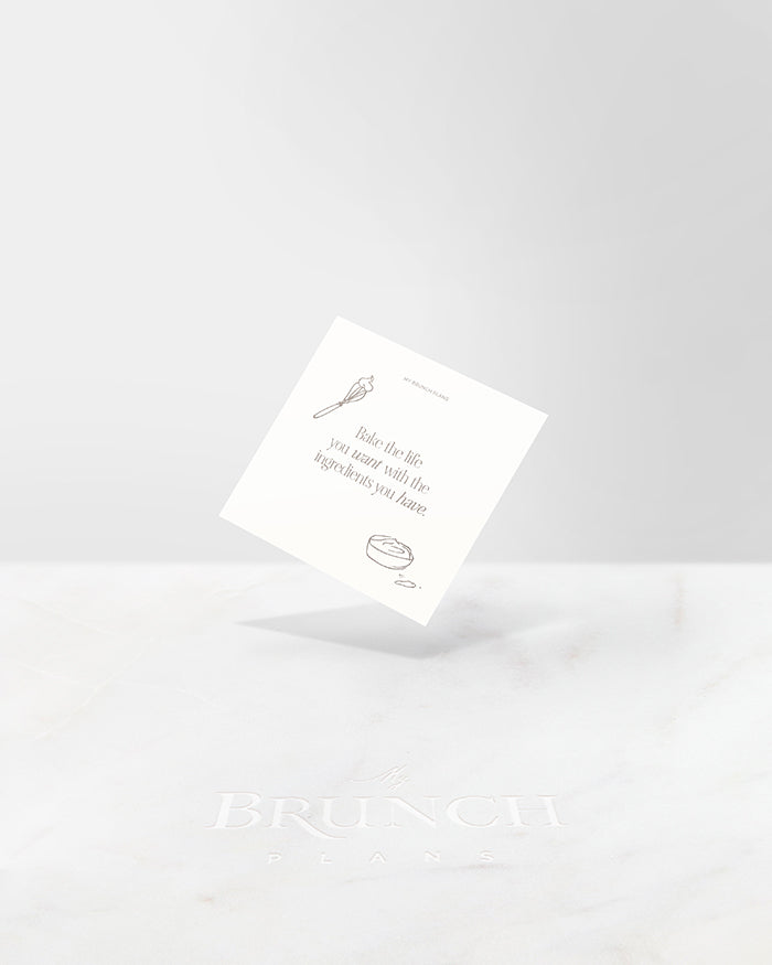 My Brunch Plans' planner card with a cream background and phrase "Bake the life you want with the ingredients you have", framed by hand drawn illustrations of a whisk with a bit of cream and a bowl of cream on a marble background.