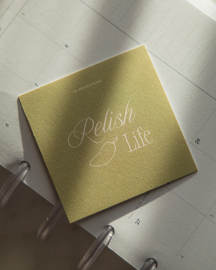 My Brunch Plans' planner card with the phrase "Relish life" on a relish green background and a hand drawn illustration of a relish on a planner.