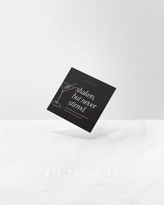 My Brunch Plans' Planner card with a dark grey background and an olive green hand drawn line art of a dirty martini on the left and side and the phrase" shaken but never stirred. Acknowledge, process and let emotions pass. Do not let your emotions define you." on a marble background.