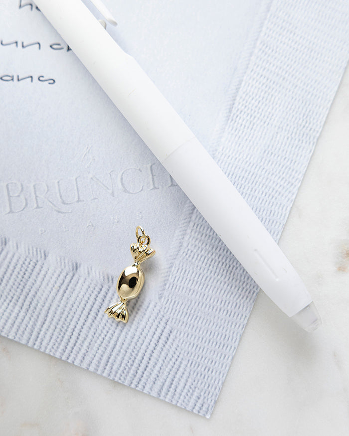 Candy Charm | 18k Gold Plated on My Brunch Plans’ Napkin notepad with a pen for size comparison.