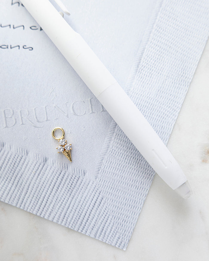 Triple Scoop Ice Cream Cone Charm | 18k Gold Plated with CZ on My Brunch Plans’ Napkin notepad with a pen for size comparison.