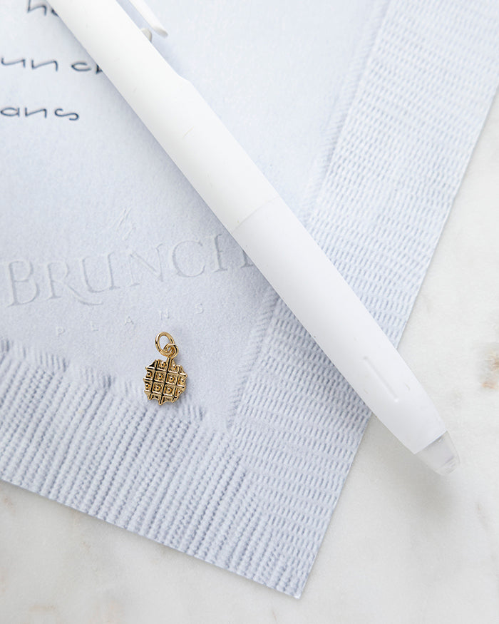 Waffle Charm | 18k Gold Plated on My Brunch Plans’ Napkin notepad with a pen for size comparison.