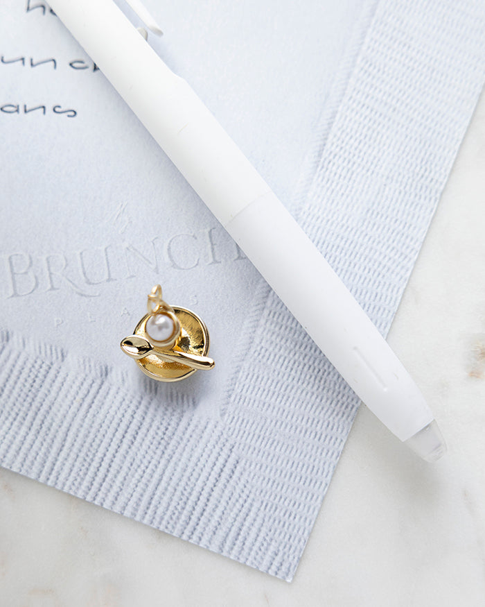 Soft Broiled Egg Charm | 18k Gold Plated with Pearl on My Brunch Plans’ Napkin notepad with a pen for size comparison.