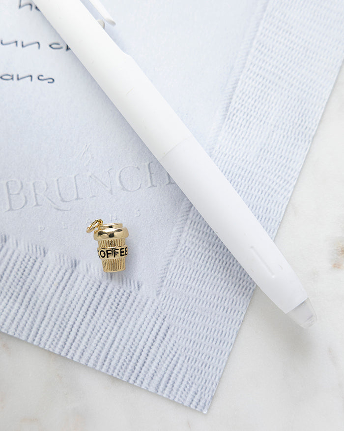 Coffee To Go Charm | 18k Gold Plated on My Brunch Plans’ Napkin notepad with a pen for size comparison.
